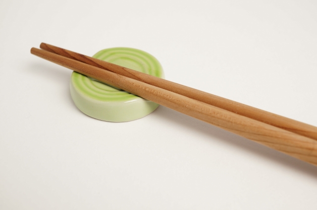 A person using chopsticks correctly to eat Japanese food.