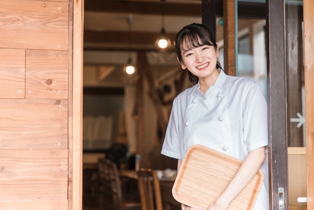 A tourist and a local Japanese person communicating with a smile and gestures.