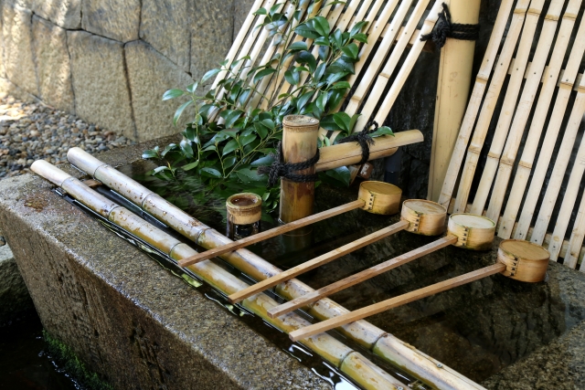 A person performing the purification ritual at a chozuya.